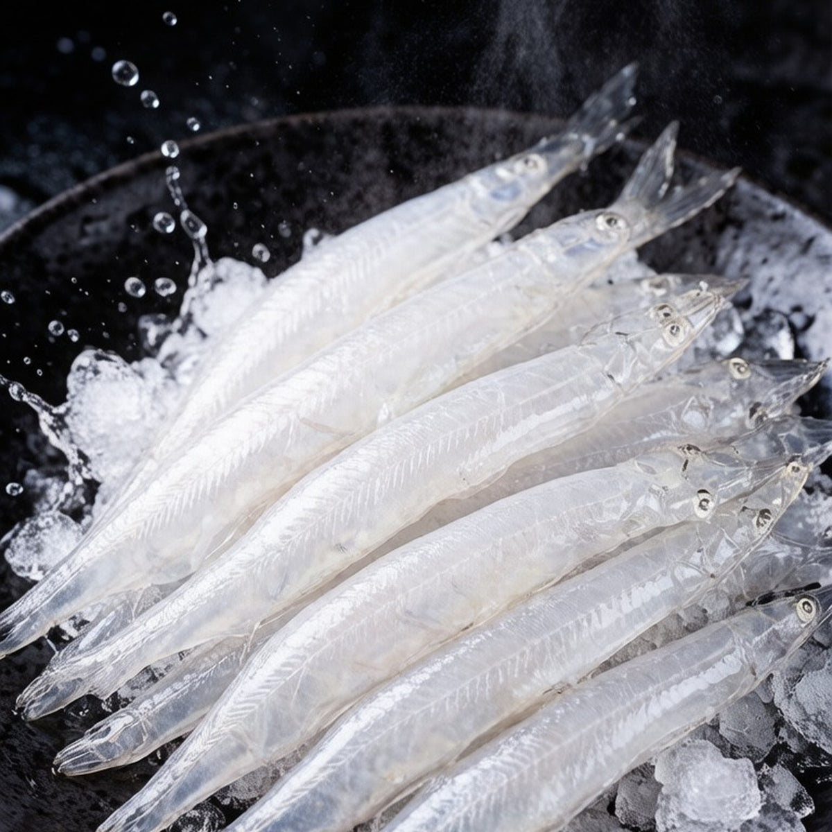 Slender translucent silver whitebait scattered over dark slate