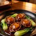Whole abalone in the shell with a plump golden-brown muscle